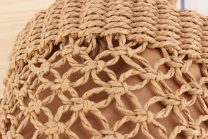 Close-up of hollow woven basket bag with premium brown lining and natural straw texture