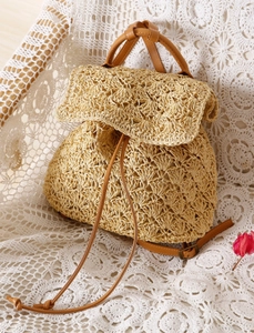 Detail of bohemian woven backpack with drawstring closure and brown faux leather straps