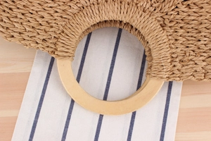 Close-up of a handwoven paper rope bag featuring a smooth round wooden handle detail