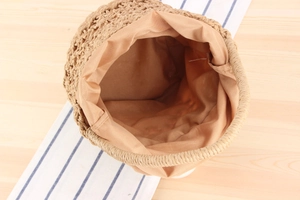 Overhead view showing the woven texture and fabric lining of this straw bucket bag