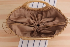 Top view of handmade woven bag with wooden handles and brown drawstring lining