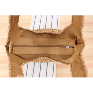 Detail view of woven bucket bag featuring secure zipper closure and cotton lining