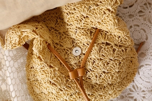 Detailed close-up of woven straw bag with magnetic closure and soft inner lining
