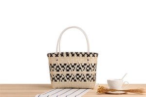 Detailed close-up of checkered woven tote bag with black and white patterns and rivets