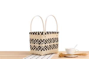 Close-up of woven checkered picnic bag with durable soft tube handles and metal rivets
