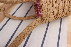 Close-up of handmade straw woven bag featuring striped lining and detailed texture