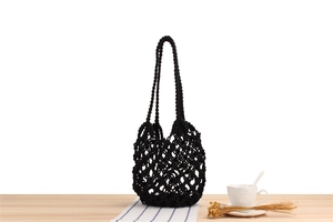 Detail of hand-woven black mesh shoulder bag with intricate hollow crochet pattern