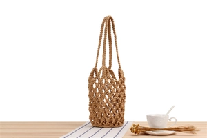 Close-up of handmade woven mesh tote bag with crochet diamond hollow pattern and thick handles