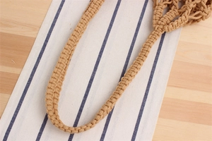 Detailed macro view of handcrafted macramé knots and woven strap texture on summer beach bag