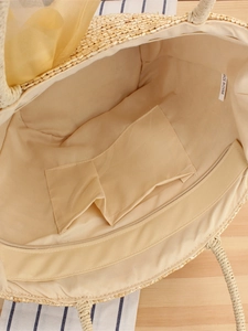Internal structure of woven straw bag with floral accents and organized pockets
