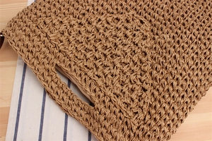 Dettaglio della borsa tote intrecciata con trama naturale e fodera in tessuto beige