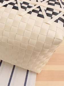 Handwoven checkerboard picnic basket bag with black and white grid patterns and twin handles