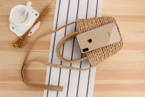 Détail du sac de téléphone en paille tressée à la main montrant sa capacité interne