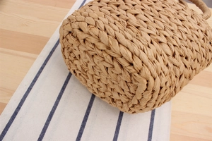 Gros plan détaillé sur la texture tissée main dense et la structure du fond d'un sac en paille