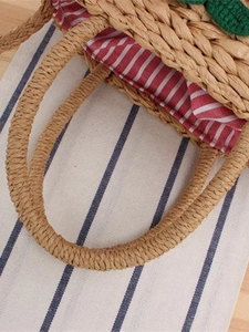 Handmade woven straw tote bag with thick handles and red striped lining for beach vacation