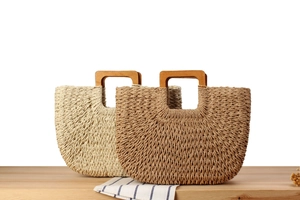 Détail de sacs cabas en paille tissés main avec anses carrées en bois beige et marron