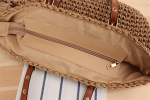 Detail of woven beach bag interior featuring lining, zipper pocket, and leather strap