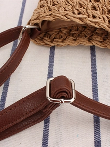 Borsa di paglia alla moda con tracolla regolabile in pelle marrone su tessuto a righe