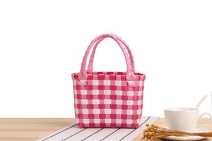 Detail der geflochtenen Tasche in Pink und Weiß mit robusten Doppelgriffen und Karomuster