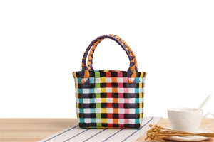 Bunter geflochtener Nylon-Minikorb auf Holztisch mit eleganter Nachmittagstee-Deko