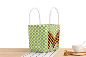 Detailed checkerboard pattern of a green and white woven tote bag with a bold letter M