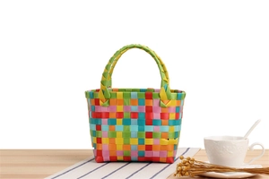 Nahaufnahme der bunten gewebten Mini-Nylontasche für Kinder und Geschenke auf dem Holztisch