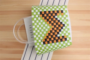 Detail of woven tote bag with green checkers, zigzag pattern and clear hose handles