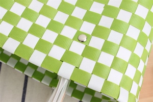 Close-up of green and white checkered woven bag showing silver metal snap button closure