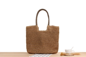 Detailed view of hand-woven straw tote bag with textured deep brown natural fibers