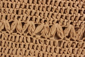 Macro shot of intricate hollow-out woven paper rope texture for summer beach shoulder bag