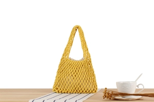 Detailed texture of yellow woven cotton rope beach bag with white fabric inner liner