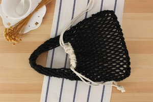 Detail of black handmade woven mesh bag with creamy white cotton rope handles