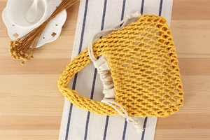Macro detail of yellow handmade cotton rope woven bag with drawstring inner pouch