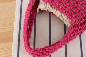 Detailed view of hand-woven macaron cotton rope bag with beige drawstring lining
