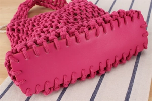 Detail of rose red woven tote bag featuring sturdy reinforced faux leather bottom base