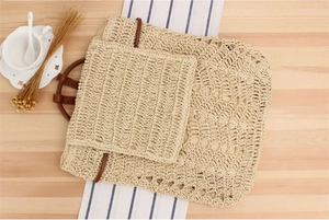 Macro shot of hand-woven straw backpack featuring hollow patterns and brown leather straps