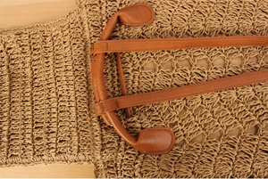 Detail of woven straw texture and premium brown PU leather handle with reinforced stitching