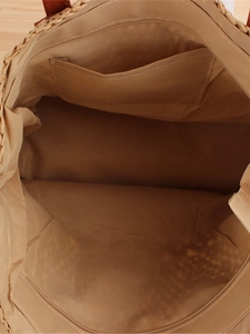 Interior view of woven straw shoulder bag with coffee fabric lining and secure zipper pocket