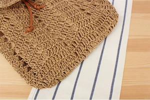 Detail of hand-crocheted paper rope pattern with a brown leather drawstring closure