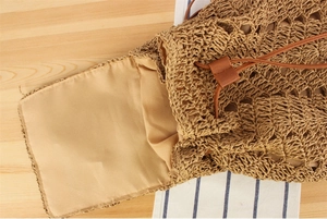 Detail of hand-woven straw backpack showing drawstring closure and fabric lining texture