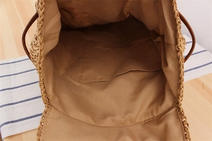 Internal view of a woven straw backpack with beige lining and a practical inner pocket