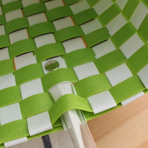 Green and white woven basket bag with metal rivet detail and transparent handles