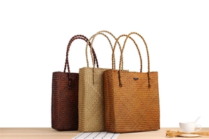 Detailed trio of woven straw tote bags in dark coffee, natural, and caramel colors