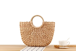 Close-up of the textured corn husk weaving and circular handle of the beach tote bag
