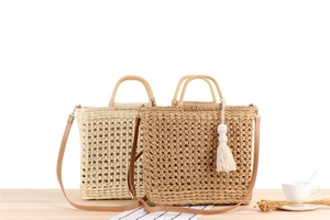 Detail of handmade woven paper rope beach bags with wooden handles and tassels
