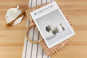 Top view of natural corn husk woven tote bag with round handles on a rustic table