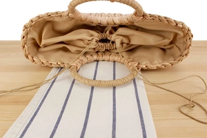 Detailed top view of handmade corn husk tote with cotton drawstring lining and round handles