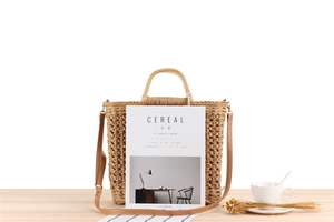 Detailed close-up of handmade paper rope woven tote bag with hollow pattern on wooden desk