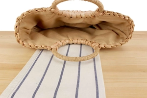 Detailed top view of natural corn husk tote showing round handles and beige fabric lining