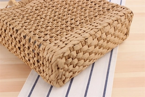 Close-up of hand-woven paper rope beach bag showing reinforced base and fiber texture